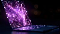 Glowing purple particles emerging from laptop screen creating magical light effect against dark background. Digital transformation concept.