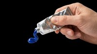 Caucasian hand squeezing blue paint from metal tube onto transparent background. Isolated design element ready for t-shirt graphics, clipart, stickers, print-on-demand products and sublimation projects.