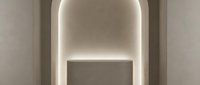 Elegant arched niche with warm LED backlight and minimalist podium in neutral beige tones, luxury interior design concept for product display.