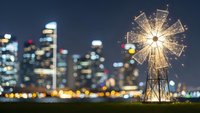Sparkler firework glowing against blurred city skyline at night creating magical celebration atmosphere for holidays and special events.