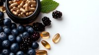 Fresh blueberries and blackberries with vitamin supplements and herbal medicine capsules on dark background, natural health concept for wellness and immunity.