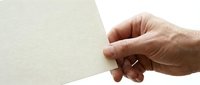 Senior man hand holding blank beige paper card mockup isolated on white background for business presentation and marketing materials design.