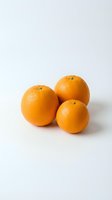 Three fresh ripe oranges grouped together on a white background, showcasing vibrant color and natural texture for food and nutrition projects.