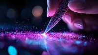 Glowing pink and blue sparkles scatter from magical pen tip against dark background with bokeh effect, creating ethereal artistic atmosphere.