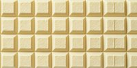 White chocolate bar texture with square segments in creamy ivory color, creating a geometric pattern of edible blocks.