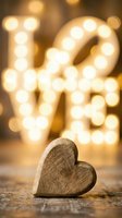 Wooden heart on rustic surface with glowing bokeh love sign in warm golden light, romantic Valentine's Day and wedding concept.