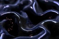 Dark navy silk fabric with flowing waves and metallic shimmer, creating elegant drapes with luxurious texture for fashion, textile, and design projects.