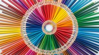 Concentric circles of sharpened colored pencils arranged in rainbow spectrum pattern, creating vibrant radial design for art, creativity, education, and design projects.