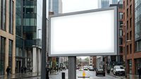 Large blank billboard mounted on metal structure spanning across urban street with modern and historic buildings, suitable for advertising mockups and commercial campaigns.