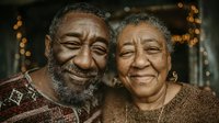 Happy elderly African American couple smiling warmly together with golden bokeh lights creating romantic atmosphere for anniversary celebrations.