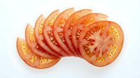Sliced ripe tomato arranged in overlapping rows on white background, isolated and ready for culinary, food styling, recipe, and cooking design projects.