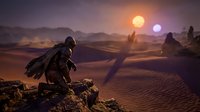 Futuristic warrior in armor sits on rocky outcrop overlooking alien desert landscape with twin suns setting behind distant mountains and rock formations.