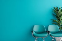 Modern turquoise chairs against matching wall with tropical plant, creating minimalist waiting area for office or reception space.