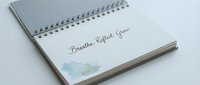 Spiral-bound notebook with watercolor accent and handwritten wellness text for mindfulness, journaling, and self-care projects.