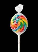 Colorful spiral lollipop with transparent cellophane wrapper and white stick, isolated on transparent background. Ready for candy shop designs, packaging, clipart, stickers, and print-on-demand products.