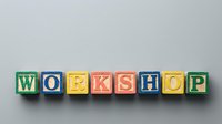 Colorful wooden alphabet blocks spelling WORKSHOP on a gray background, representing education, training, and creative learning events.