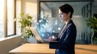 Businesswoman in formal attire working on laptop with digital holographic interface and data visualization in modern office environment with plants and natural light.