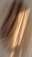 Soft flowing fabric with warm golden and neutral tones creating elegant curved folds and drapes. Suitable for backgrounds, textile design, and luxury branding projects.