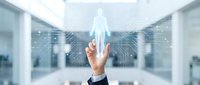 Business hand touching digital human hologram icon in modern office environment representing HR technology and workforce management solutions.