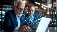 Senior Caucasian businessmen working on laptop with glowing digital network visualization effect, modern office environment with bokeh lights.
