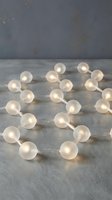 Warm white LED globe string lights arranged in heart shape on concrete surface with industrial gray backdrop, suitable for home decor, events, and festive celebrations.