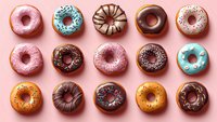 Colorful glazed donuts with chocolate, sprinkles and various toppings arranged in neat rows on pink background, top view flat lay composition for food design.