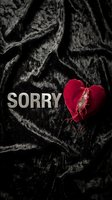 Torn red velvet heart and silver sorry letters on dark crumpled fabric, expressing apology, regret, and heartbreak emotions.