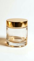 Empty clear glass jar with a shiny gold metallic lid, isolated on white background, for cosmetic, candle, or food packaging mockup design.