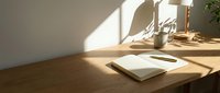 Minimalist wooden desk workspace with open notebook, pen, and potted plant bathed in warm natural sunlight from window, suitable for office and productivity concepts.