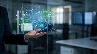 Businessman holding glowing digital network connections with data particles floating above palm in modern office environment for technology presentations.
