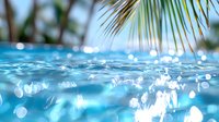 Tropical underwater scene with sunlight streaming through crystal clear turquoise water, palm fronds visible above surface creating dreamy summer atmosphere.