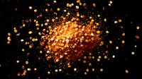 Explosive burst of glowing orange and gold particles scattered against dark background creates dynamic motion effect for dramatic design projects.
