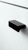 Modern black cabinet handle on white furniture drawer showcasing minimalist interior design and contemporary home decor hardware for kitchen renovation projects.