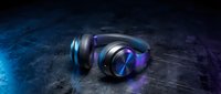 Over-ear headphones with glowing blue and purple neon lights on dark textured surface, suitable for music, gaming, and audio equipment marketing.