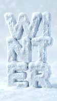 Frozen ice letters spelling WINTER covered in snow and icicles, standing in snowdrift on light blue background for seasonal design.
