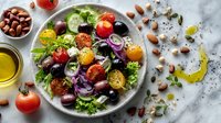Fresh Mediterranean salad with mixed greens, cherry tomatoes, olives, feta cheese and nuts on marble background. Healthy vegetarian meal concept.