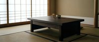 Minimalist low wooden table in serene Japanese-style room with tatami mats, shoji screens, and neutral tones for zen interior design projects.