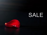 Red glossy heart shape on dark surface with SALE text for Valentine's Day marketing, romantic promotions, love-themed advertising campaigns and retail sales.