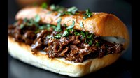 Savory braised beef sandwich with caramelized onions and fresh herbs on crusty bread roll, comfort food for restaurant menus and culinary marketing.