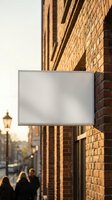 Blank white signage mockup on brick building wall during golden hour sunset with warm lighting for branding and advertising display purposes.