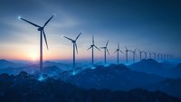 Wind turbines generating renewable energy at sunset with mountain landscape and blue sky creating sustainable power for environmental conservation.