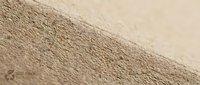 Close-up of fine sand texture with natural grain patterns and soft lighting creating depth and shadow details for backgrounds and natural material concepts.