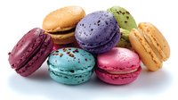 Colorful French macarons in vibrant purple, pink, turquoise, burgundy, orange and pistachio green colors arranged on white background, isolated sweet meringue cookies.