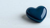 Glossy dark blue heart shape on white background with soft shadow, minimalist romantic symbol for love, relationships and emotional concepts.