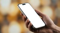 Person with medium skin tone holding smartphone with blank white screen for app mockup or advertising purposes against blurred background.
