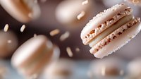 Delicate white macarons with coconut flakes floating in air against dark background, soft focus creates dreamy atmosphere for food photography and menu design.
