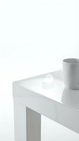 Minimalist white table with gray ceramic mug in clean modern interior setting for contemporary home decor and lifestyle design concepts.