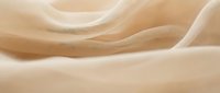 Flowing beige silk fabric with soft waves and elegant drape creates luxurious textile background for fashion and interior design projects.