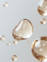 Floating golden drops with air bubbles against light background, macro photography of liquid cosmetic serum or essential oil in motion, luxury skincare concept.