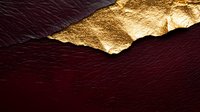 Luxurious burgundy leather texture with torn gold foil accent creating dramatic contrast and elegant surface detail. Suitable for luxury brand designs and premium packaging.